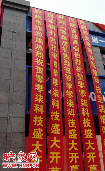 路邊一棟樓上懸掛著二三十條紅色條幅，全部是祝賀一家公司開業(yè)的。