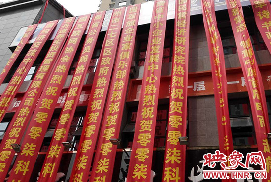 路邊一棟樓上懸掛著二三十條紅色條幅，全部是祝賀一家公司開業(yè)的。