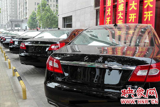 路邊一棟樓上懸掛著二三十條紅色條幅，全部是祝賀一家公司開業(yè)的。