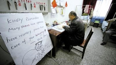張大爺在門衛(wèi)室里工作，旁邊是紅爆網(wǎng)絡(luò)的溫馨提示牌記者
