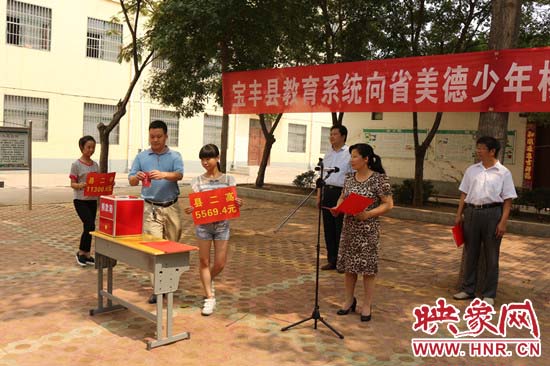 寶豐縣教育系統(tǒng)全體人員在石橋鎮(zhèn)中學(xué)為“美德少年”楊冠明同學(xué)捐款。
