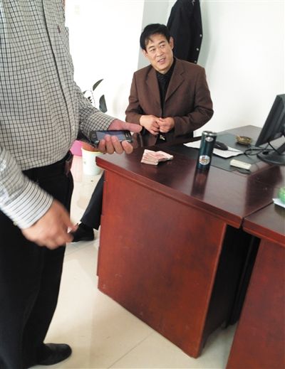 10月29日，獻(xiàn)縣國(guó)稅局稽查局辦公室內(nèi)，一名企業(yè)主交了兩萬元現(xiàn)金在桌上。新京報(bào)記者 孟祥超 攝
