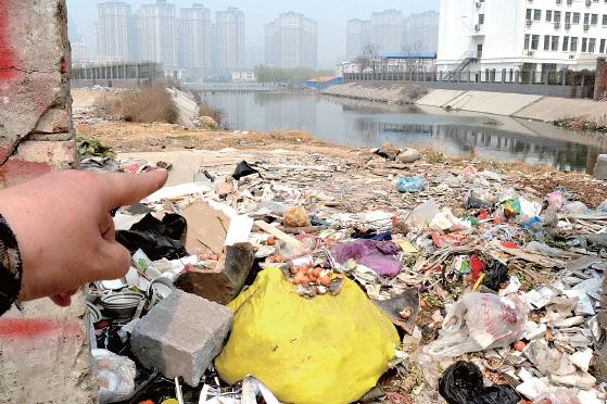 金水河長江路橋下河水發(fā)臭，水邊堆放眾多垃圾