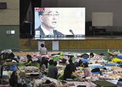 27日，韓國珍島，“歲月”號客輪乘客家屬在體育館觀看總理鄭烘原辭職新聞。當日，鄭烘原召開緊急發(fā)布會，表示對韓國“歲月”號沉船事件負責，宣布引咎辭職。