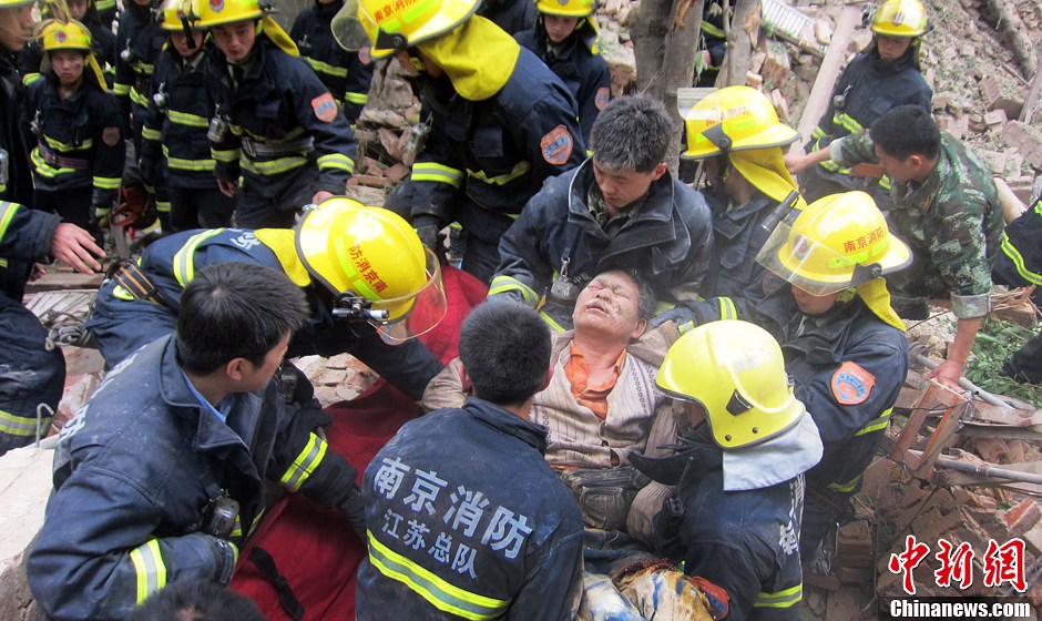 圖為南京消防隊員從廢墟中將傷者抬出。中新社發(fā) 梅亮 攝