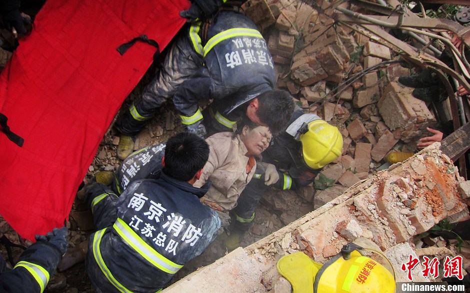 圖為南京消防隊員從廢墟中將傷者抬出。中新社發(fā) 梅亮 攝