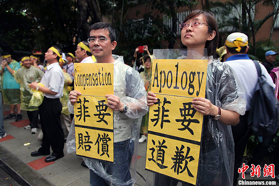 　圖為當(dāng)天下午，當(dāng)臺(tái)灣數(shù)百漁民在馬尼拉經(jīng)濟(jì)文化辦事處前抗議時(shí)，有兩名年輕人手持標(biāo)語，在路邊聲援。中新