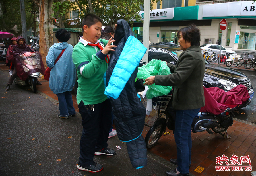 學校門口，家長給孩子帶來了御寒的厚衣服。