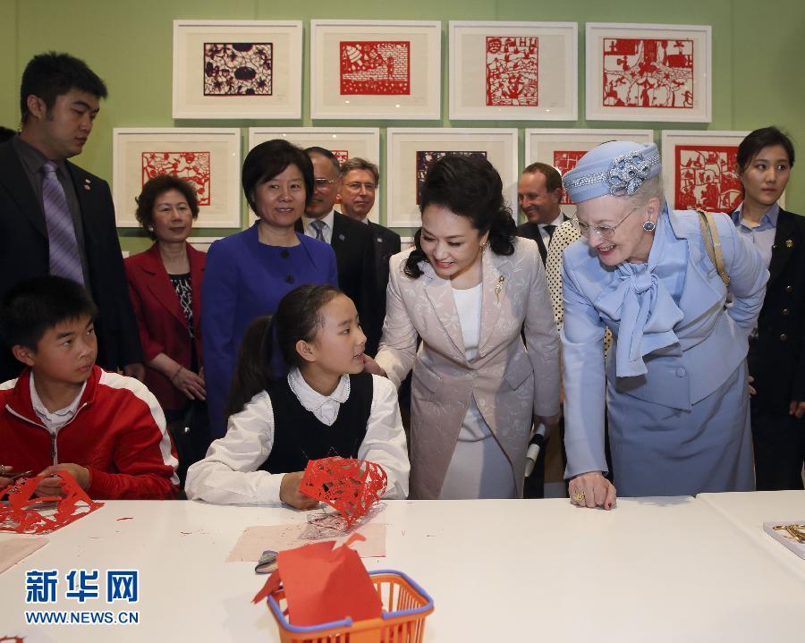 這是彭麗媛和瑪格麗特二世與根據(jù)安徒生童話中人物和情節(jié)制作剪紙的孩子交談。