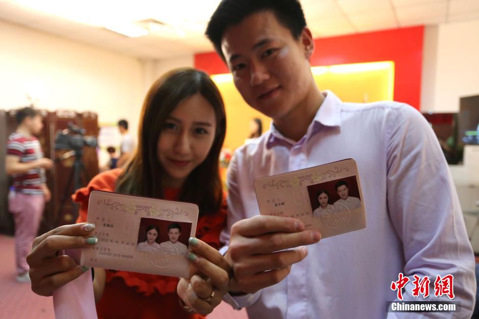 5月20日,河南鄭州,一對(duì)準(zhǔn)新人領(lǐng)完結(jié)婚證后秀自拍。