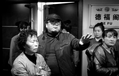 昨日，在河北香河天下第一城，相關(guān)負(fù)責(zé)人（左二）走出會議室與參加演出的老人們溝通。