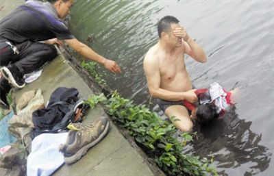 網(wǎng)友貼出民警張光聰一出河水就睜不開眼，用手抹去臉上臟水的照片。
