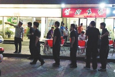 6月13日晚10點，朝陽區(qū)國美第一城附近，一名城管隊員帶領(lǐng)一隊協(xié)管例行巡查街邊大排檔。新京報記者 尹亞飛 攝