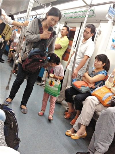 6月27日，舒馨帶一女孩在地鐵十號線行乞。她因被疑帶多個(gè)不同小孩乞討被警方搜尋。新京報(bào)記者 申志民 攝