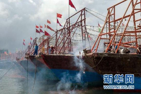 2013年8月1日 南海開漁日 臨高迎新港 8月1日，海南省臨高縣漁民在船上鳴放鞭炮慶祝武蓮港開港。