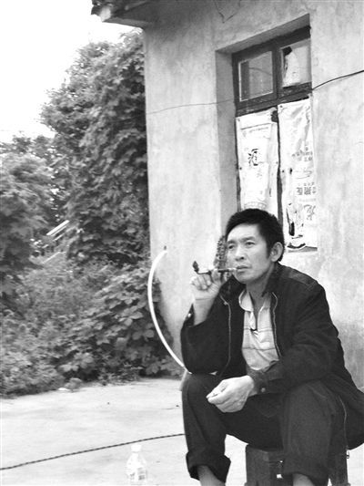 9月12日，陳文才在自己的出租屋旁抽煙。新京報(bào)記者 朱柳笛 攝