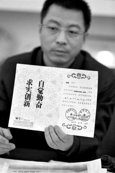 昨日，首師大美術(shù)學(xué)院黨委書(shū)記出示被騙學(xué)生的錄取通知書(shū)，表示“本科”字樣是由招生公司虛假宣傳、擅自添加。新京報(bào)記者 浦峰 攝