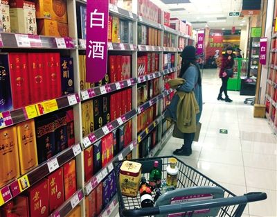 顧客在商場的高檔白酒貨架前駐足挑選。春節(jié)臨近，受“禁令”影響，以高檔白酒為代表的節(jié)日禮品市場面臨考驗(yàn)。記者 王遠(yuǎn)征 攝
