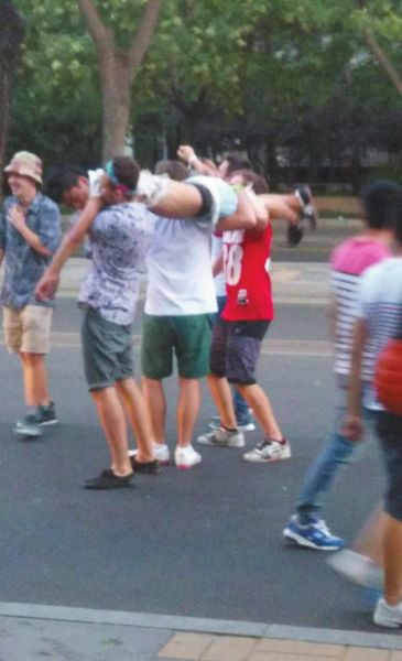 　四名外籍男子一同扛起醉漢拍照。