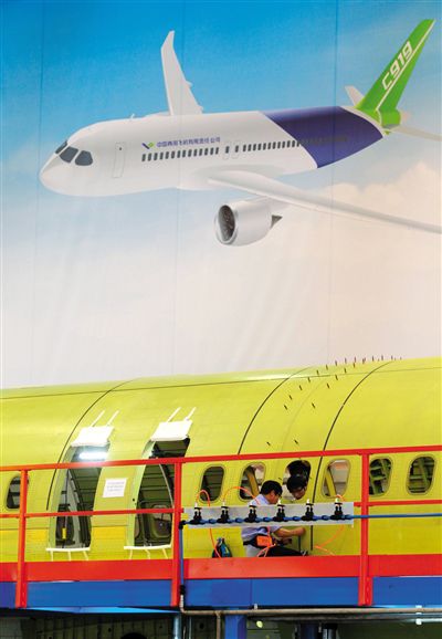 昨日，中國商飛總裝制造中心技術人員對接C919首架機的機體。新華社記者 丁汀 攝