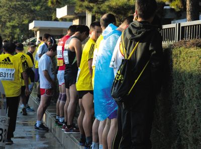 2013年10月20日，北京馬拉松比賽，由于廁位有限，一些選手在綠化帶“就地解決”。圖/IC