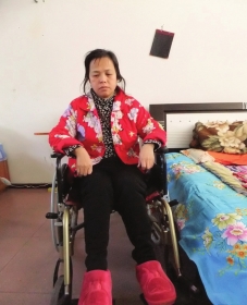 陳慶霞坐在輪椅上。她現(xiàn)在下身癱瘓，疾病纏身，生活不能自理。