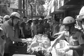 7月11日，瀏陽市北正中路，執(zhí)法人員暫扣張海的水果。這是瀏陽市城管局拍攝的執(zhí)法現(xiàn)場(chǎng)圖。