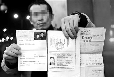 賀先生向記者出示他與越南妻子的結(jié)婚證、新娘護(hù)照和部分相關(guān)交費(fèi)單據(jù) 攝影/本報(bào)記者　袁藝