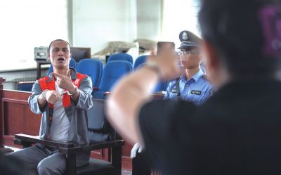 張志國在法庭上用手語回答提問。記者 蒲東峰攝
