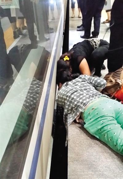 一女子趴在站臺(tái)上，救跌入列車和站臺(tái)間隙的男童。網(wǎng)友璀璨的星月夜 攝