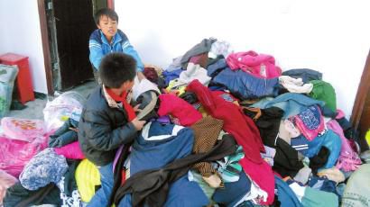 學(xué)生在幫忙整理收到的捐贈(zèng)衣服。得石中心校供圖