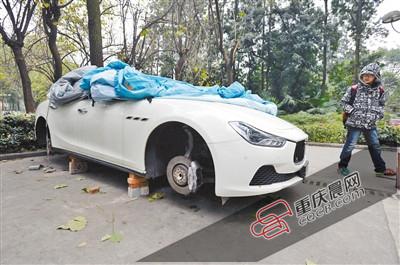 昨日，停放在重慶大學(xué)B區(qū)的一輛瑪莎拉蒂豪車被架在幾塊磚頭上，車輪不翼而飛。 重慶晨報(bào)記者 胡杰 攝