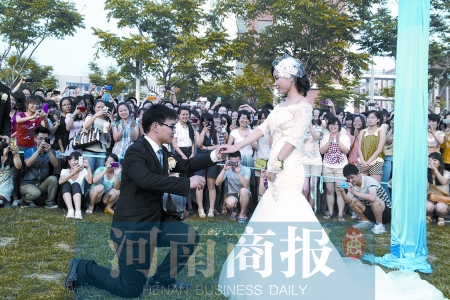 在學(xué)校操場的草坪上，兩名畢業(yè)生舉行婚禮，有同學(xué)感動地抹起眼淚