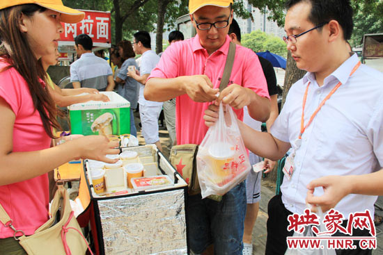 圖為徐貴雨和一名勤工助學(xué)的學(xué)生在街頭義賣快餐。
