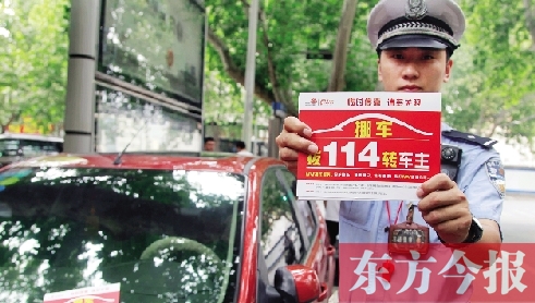 8月27日，鄭州市緯一路與經(jīng)七路交叉口，交警將“挪車請撥打114轉(zhuǎn)車主”的提示牌放在路邊?？康能嚿? width=