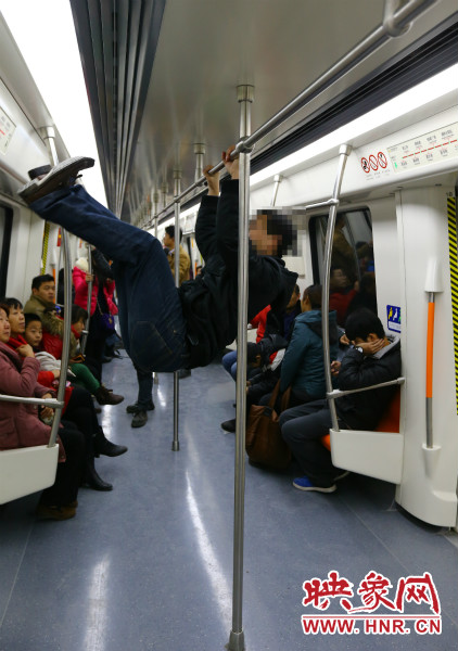 地鐵試乘日，一男子在車廂內(nèi)攀爬扶手自娛自樂