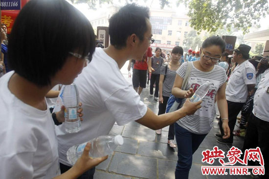 志愿者為剛剛考試完的考生送上1瓶冰凍的冰露·純悅，消暑解渴為考生加油
