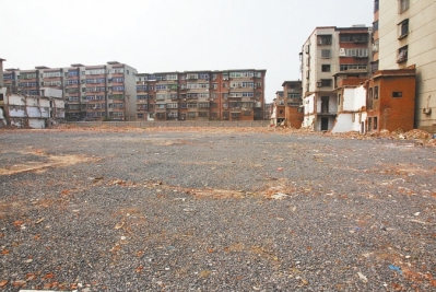 為降塵，旮旯王村拆遷后裸露的地面上鋪了一層石子。