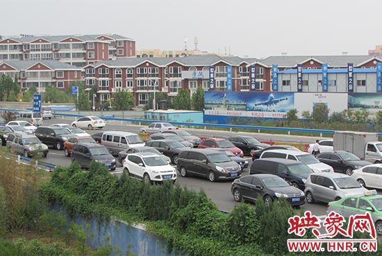記者看到鄭州機場收費站口車輛排隊，與此形成鮮明對比的是，路的對面（另一半幅）卻車輛較少，通行順暢。