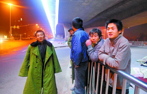 冬夜里，農(nóng)民工在橋下等著干活兒。