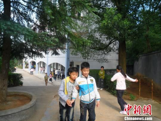 4年來(lái)，13歲的余興泉（左一）每天都攙扶著腿腳不便的同學(xué)左臣進(jìn)出教室、食堂和廁所。 李俊杰 攝