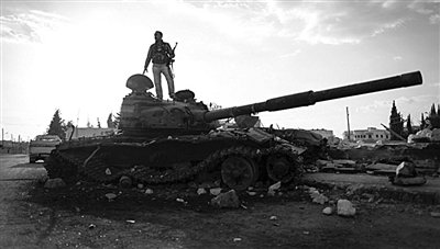9月8日，敘利亞Zabadani，一名敘利亞反對派武裝人員站在廢棄的政府軍坦克上。