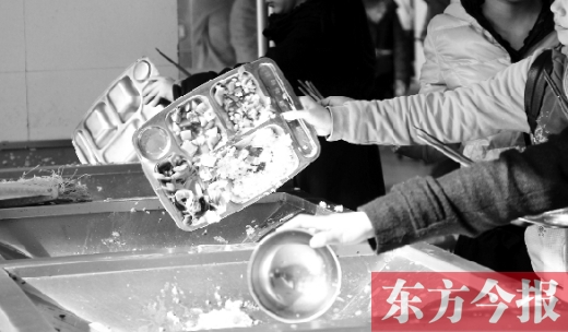 11月27日，河南中醫(yī)學(xué)院餐廳，一名同學(xué)將餐盤內(nèi)沒吃完的食物倒入餐具回收車內(nèi)