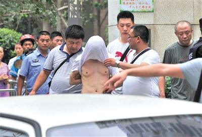 昨日，成都警方抓捕時(shí)與毒犯發(fā)生槍戰(zhàn)。一名男犯罪嫌疑人被警方押出。