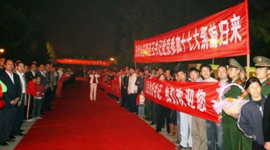 “夾道歡迎”中不少人打出橫幅，路上被鋪上了紅毯。
