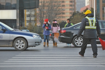 過(guò)斑馬線，行人左顧右盼，汽車(chē)寸土必爭(zhēng)。