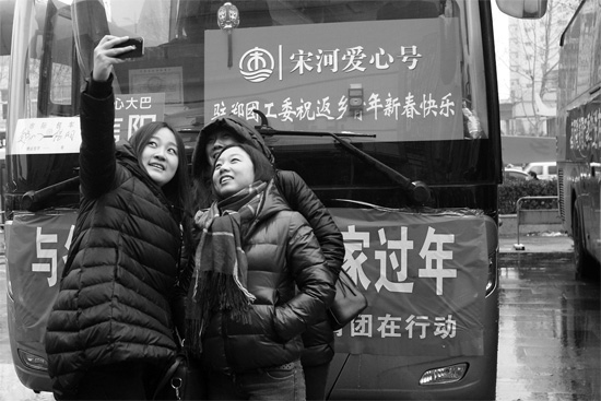 昨天上午8時(shí)，鄭州正道中環(huán)百貨廣場(chǎng)，準(zhǔn)備回家的老鄉(xiāng)在愛心大巴車前合影留念