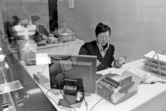 2月16日，鄭州市自來水總公司鄭東新區(qū)一營業(yè)廳，柜臺內(nèi)工作人員正在為市民辦理業(yè)務