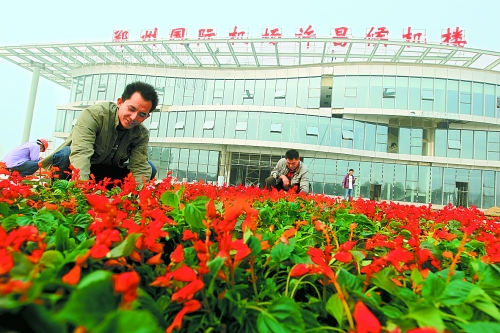 9月23日，工人們正在鄭州國際機(jī)場許昌候機(jī)樓前擺放鮮花。