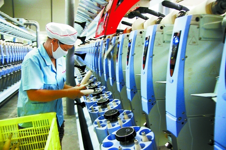 7月3日，在鄧州市永泰棉紡有限公司電腦控制全自動紡紗車間，紡織工人正在生產(chǎn)棉紗。